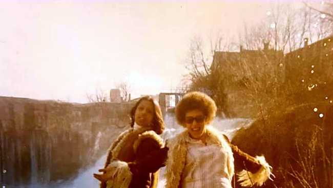 Cynthia and Cathy smith wearing their finest 70's furry fashion by a waterfall