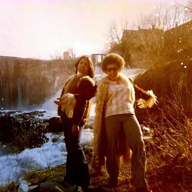 Cynthia and Cathy smith wearing their finest 70's furry fashion by a waterfall