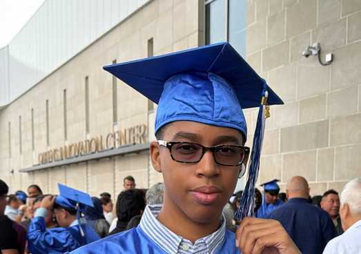 Liam standing in graduation cap and gown