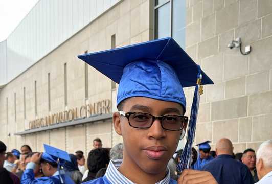 Liam standing in graduation cap and gown