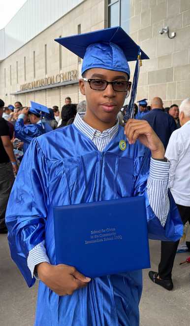 Liam standing in graduation cap and gown